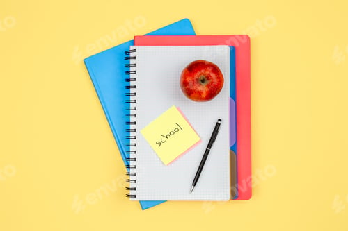 Preview: Notebooks, apple, pen and paper reminder with the word school.