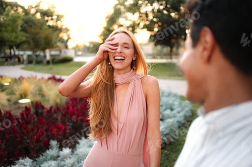 Preview: Joyful laughter shared between two friends at sunset in a vibrant park