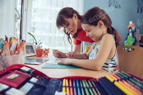 Preview: Mother helping girl doing her schoolwork at home