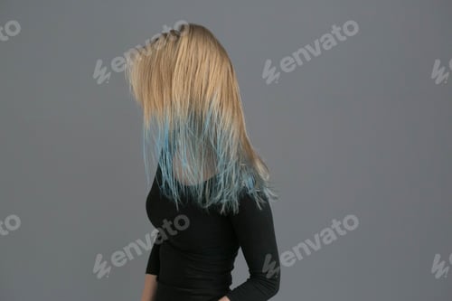 Preview: Woman color hair with blue colored hairstyle ower gray wall