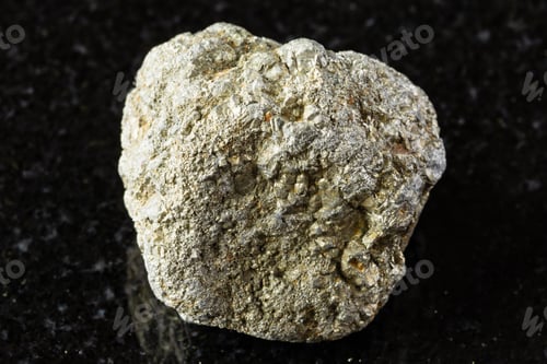 Preview: sample of uncut pyrite mineral on black granite