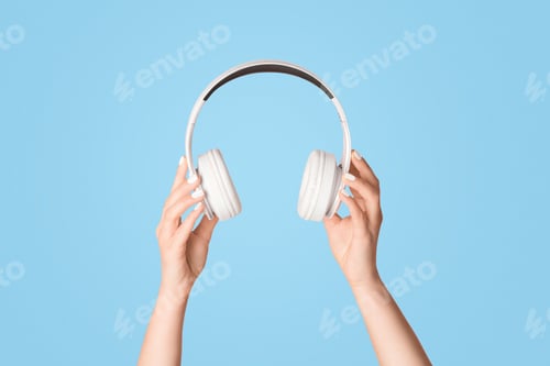 Preview: Cropped view of young girl holding headphones on pink background