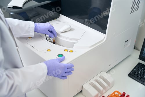 Preview: Laboratory assistant removes a test tube from a hematological analyzer