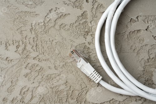 Preview: White network cable patch-cord on gray textured background