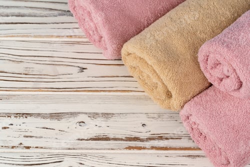 Preview: Stack of rolled towels on a wooden table