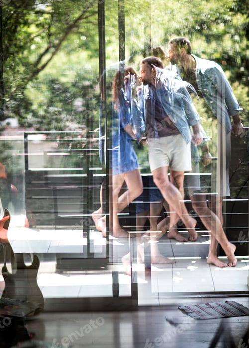 Preview: A couple standing on a balcony kissing, seen through a glass door.