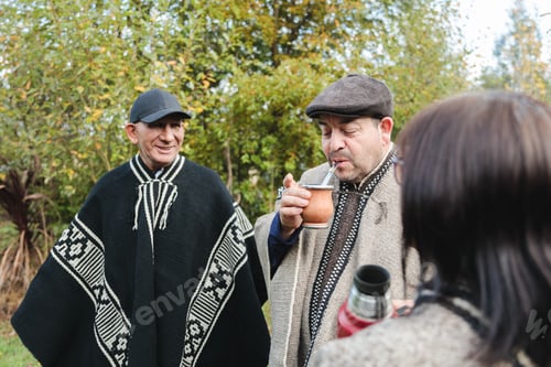 Preview: Smiling senior friends with drinks in park together