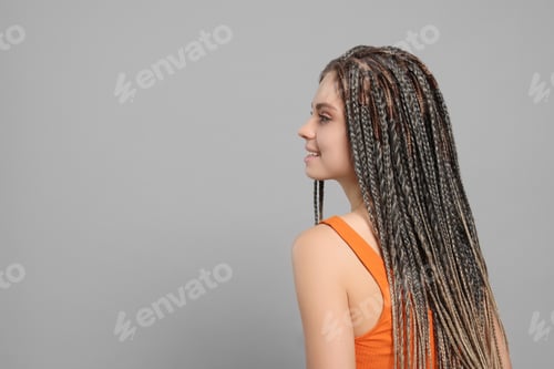 Preview: Beautiful woman with long african braids on grey background, space for text