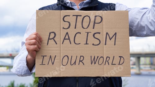 Preview: Stop racism concept. Unrecognizable white person holds sign with text against racist.