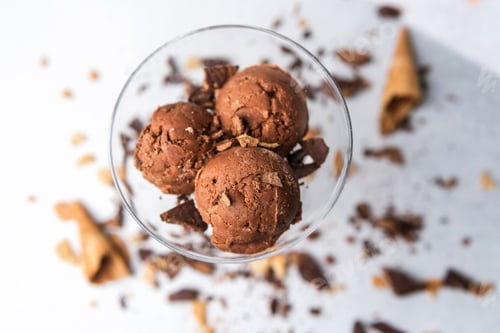 Preview: Top view of chocolate ice cream scoops in glass with waffle and chocolate pieces