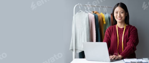 Preview: Asian beautiful cloth owner using laptop computer while planning her new concept for her new collect