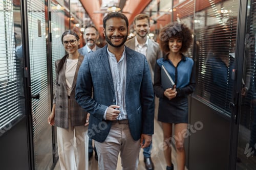 Preview: Group of happy, motivated business people standing together at office with their leader