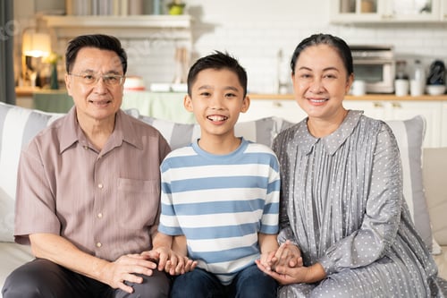 Preview: Happy Asian grandson and grandparents relax sitting on couch in the living room