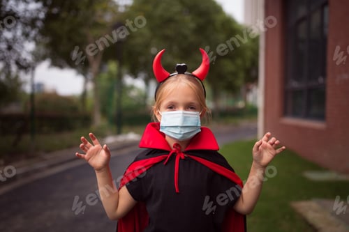 Preview: Happy kid in evil costume celebrating Halloween 2020 during coronavirus covid-19 pandemic