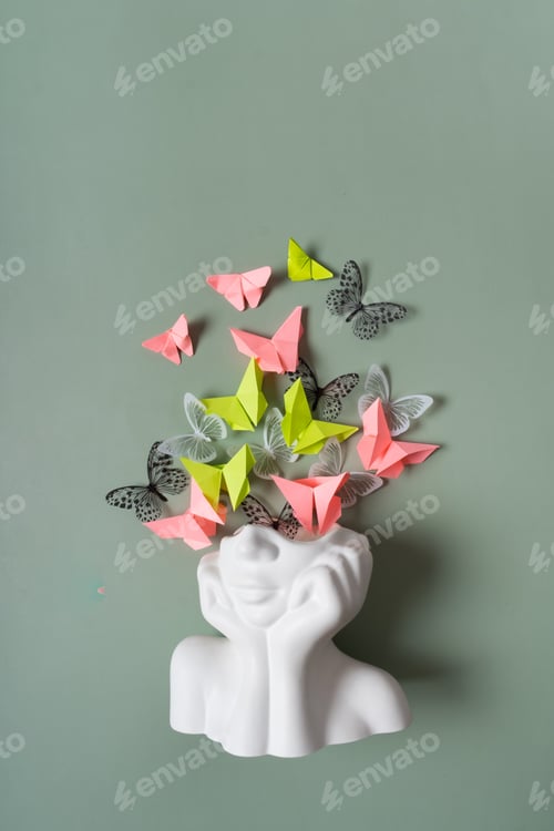 Preview: A figurine of a head with butterflies on a colored background. Mental health concept