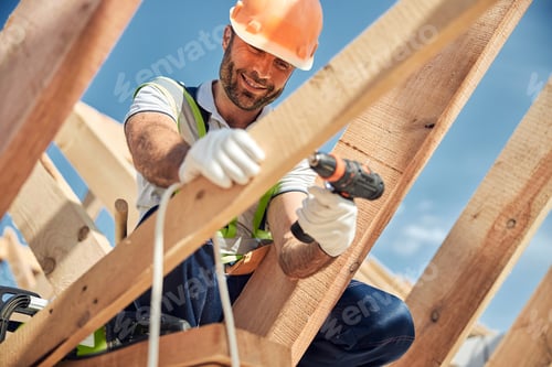 Preview: Positive delighted bearded man fixing crews into board