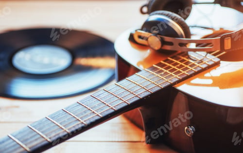 Preview: Classical guitar with headphones on a wooden background