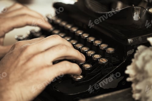 Preview: Young man's hands typing on an antique vintage typewriter