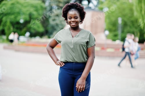 Preview: African girl posed at street of city wear on green blouse and blue pants.