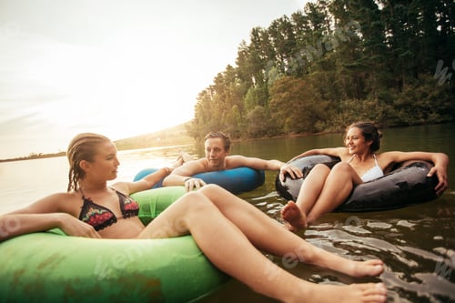 Preview: Friends floating on lake with inflatable rings