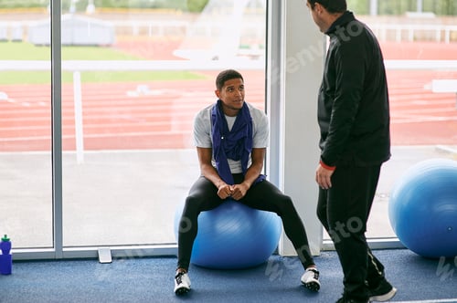 Preview: Man Seated on Exercise Ball Talking to Colleague