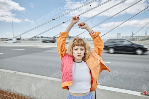 Preview: Woman Poses With Arms Raised on Bridge