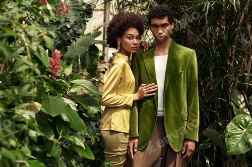 Preview: Young couple enjoys a romantic moment surrounded by vibrant greenery in a greenhouse setting