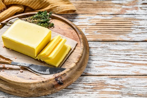 Preview: Block of fresh Butter, dairy farm products. White wooden background.Top view. Copy space
