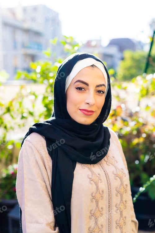 Preview: Elegant woman in traditional headscarf posing outdoors with a gentle smile