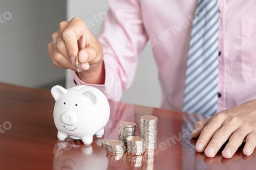 Preview: Businessman hand putting coin money into white piggy bank