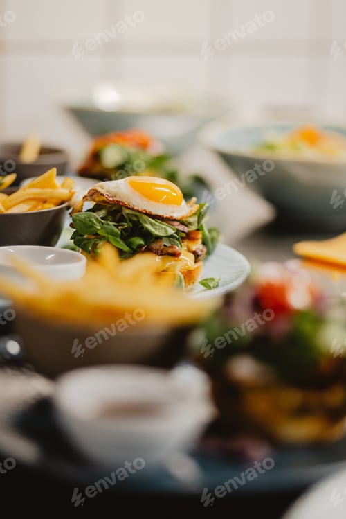 Preview: Vertical closeup shot of a gourmet burger being prepared at a restaurant table