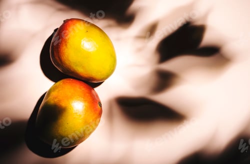 Preview: Summer mango fruits top view. Contemporary still life, lpink background, hard light and shadow