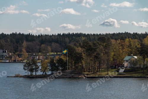 Preview: view from the ship to the rocky coast of Sweden. typical swedish houses on the rocks. cloudy sky