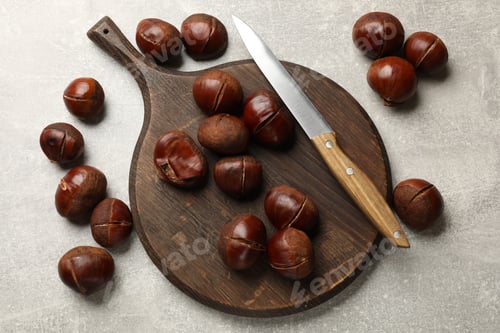 Preview: Fresh edible sweet chestnuts and knife on grey table, flat lay
