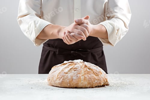 Preview: The male hands in flour and rustic organic loaf of bread