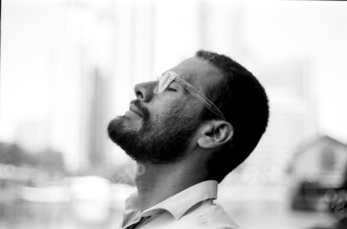 Preview: Bearded man wearing glasses relaxing with eyes closed in monochrome