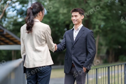 Visualização: Empresários apertando as mãos fazendo acordo ao ar livre