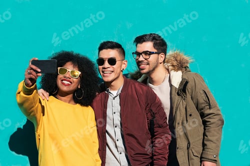 Preview: Group of happy friends taking a selfie in the street.