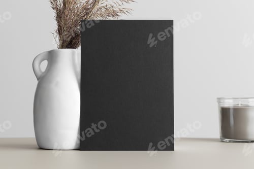 Preview: Black invitation card mockup with a dried flower on the beige table. 5x7 ratio, similar to A6, A5.