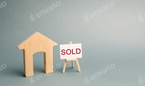 Preview: A miniature wooden house and a poster with the inscription Sold