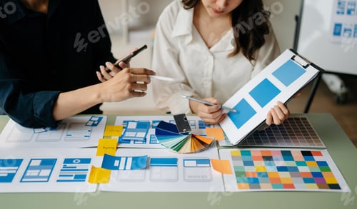 Preview: UI developer team brainstorming on their project with laptop, smartphone