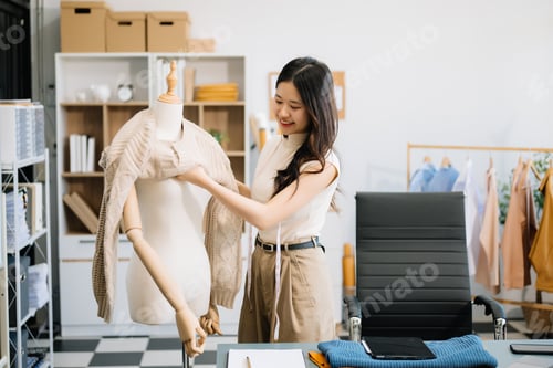 Preview: Successful fashion designer. Attractive young asian woman with smile while standing in workshop.