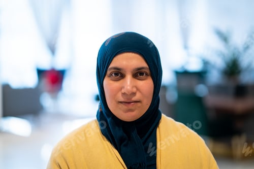 Preview: Positive adult Middle Eastern woman with hijab indoors