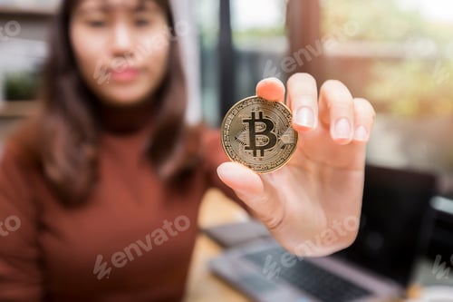 Preview: Golden bitcoin (cryptocurrency) in hand of businesswoman. New Virtual money concept