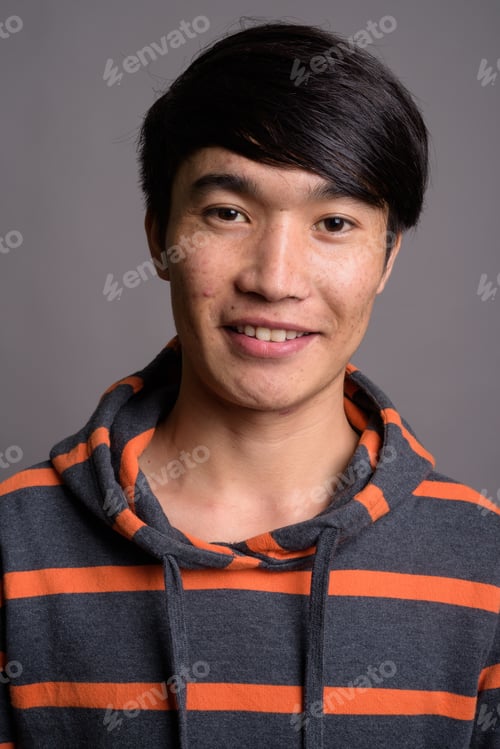 Preview: Young Asian man wearing striped hoodie against gray background