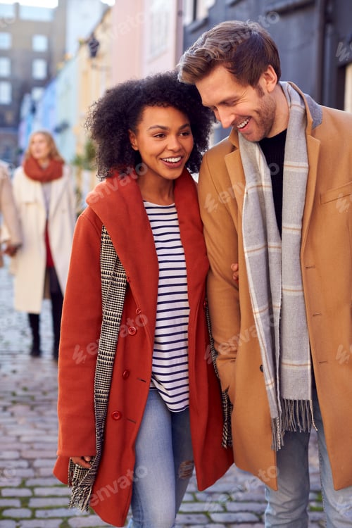 Preview: Multi Cultural Couple With Friends Walking Along Residential City Street In Fall Or Winter