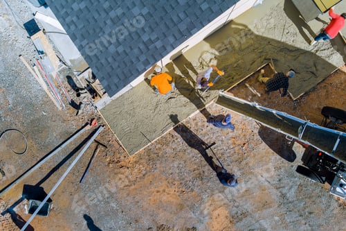 Preview: A concrete mixing truck pours concrete onto the building site surrounding a newly constructed home