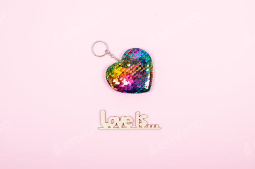 Preview: Valentines day pastel minimal creative background. Text Love is and rainbow Lgbt gay heart on pink