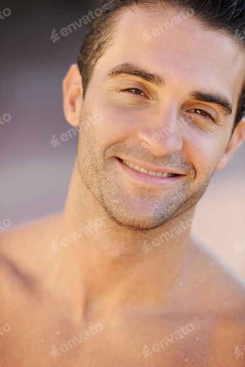 Preview: Hunky handsomeness. Closeup of a handsome young topless man smiling at the camera.