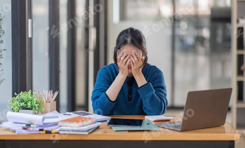 Preview: Portrait of tired young business Asian woman work with documents tax laptop computer in office. Sad,